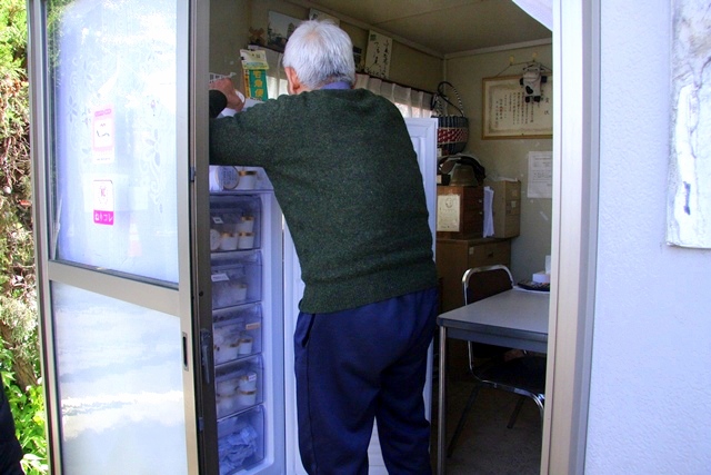 冷蔵庫からアイスを取り出す小泉牧場の経営者、小泉興七さん
